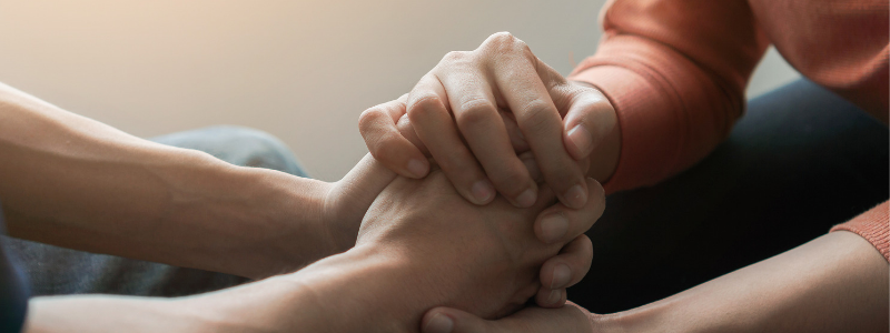Hands holding offering support for mental health