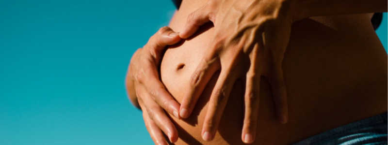 Hands holding pregnant stomach